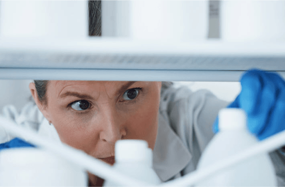 woman checks bottles on shelf